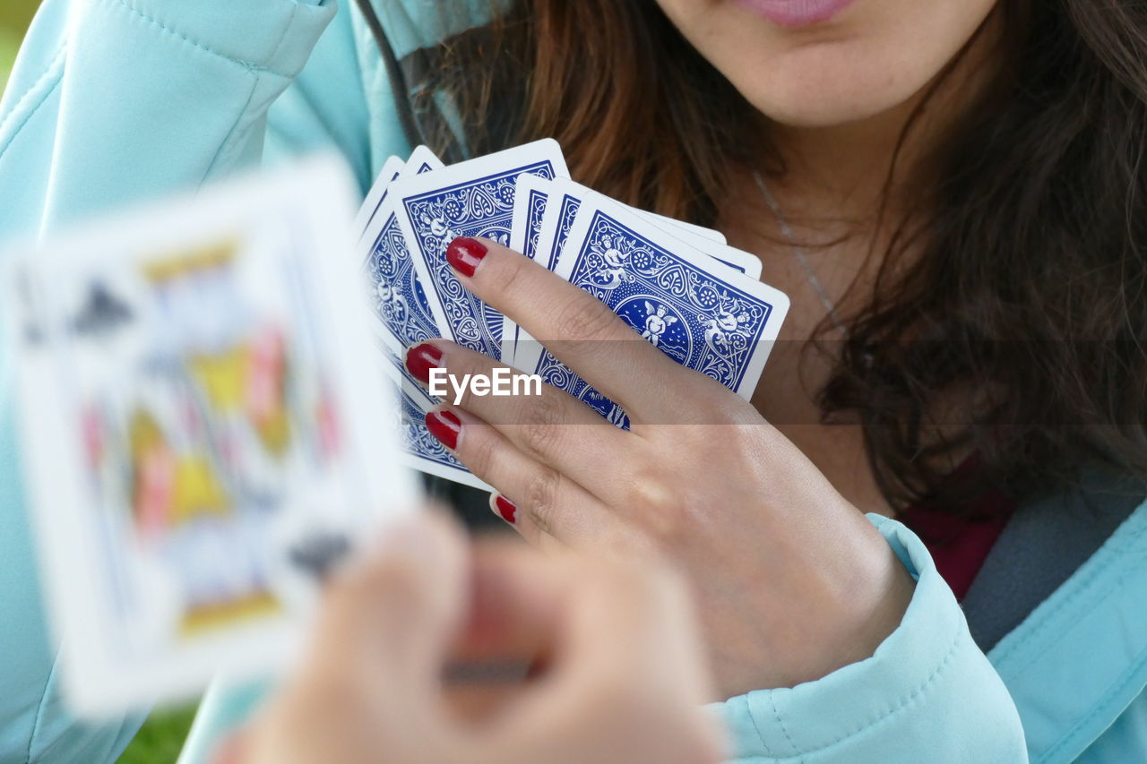 Midsection of woman playing cards