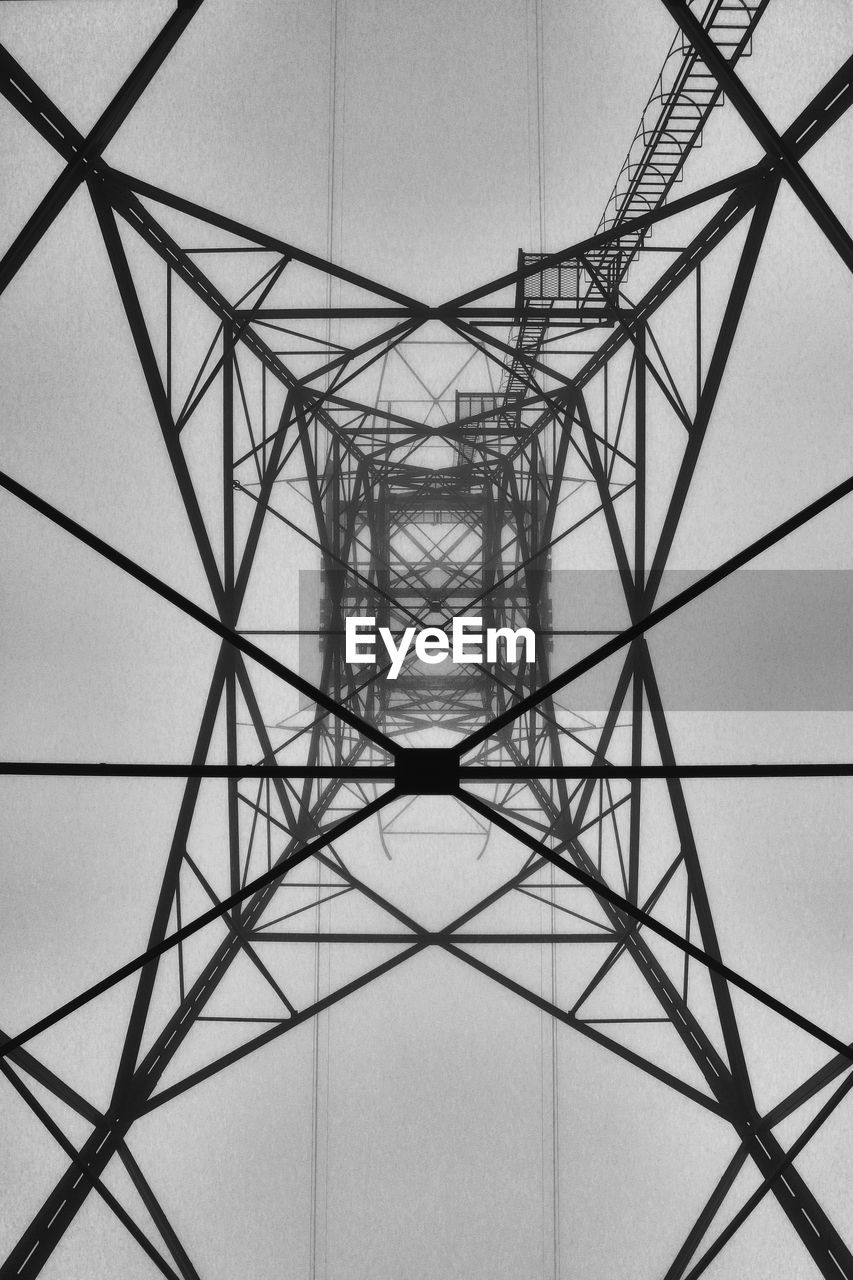 Directly below shot of electricity pylon against sky