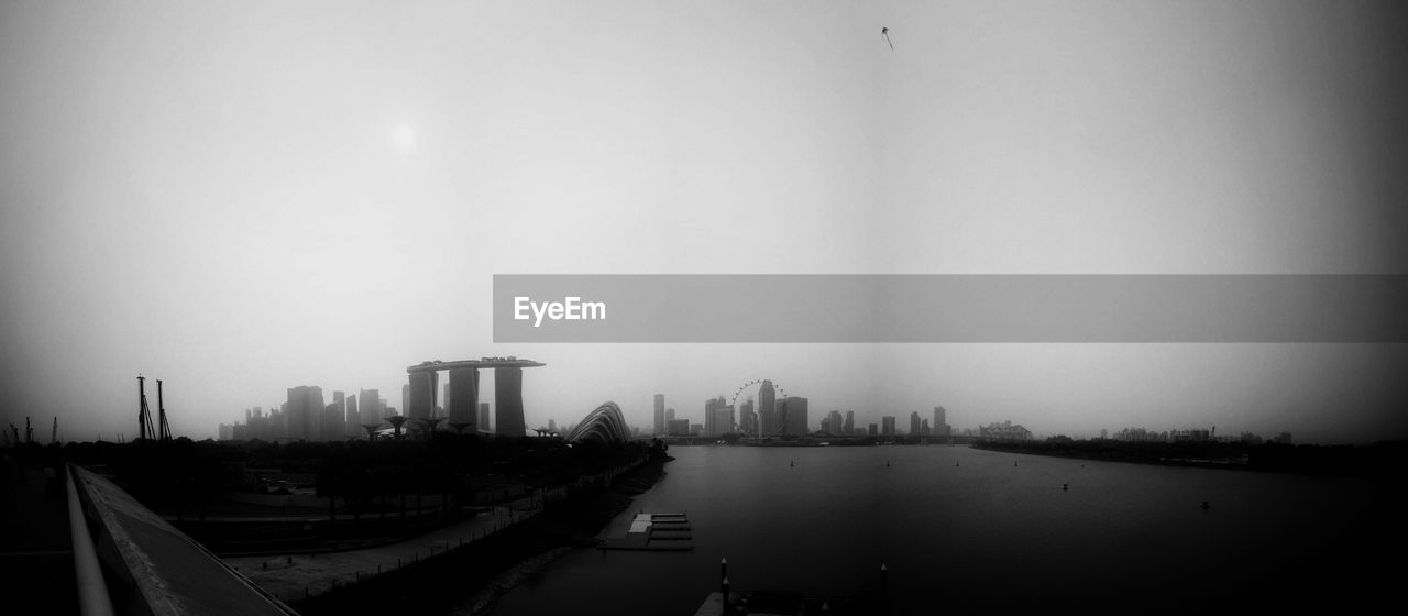Panoramic shot of marina bay sands by sea against sky at dusk