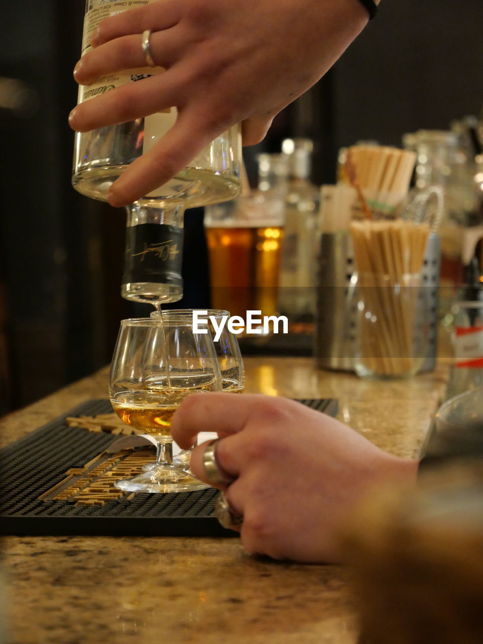 cropped hand of woman holding beer glass