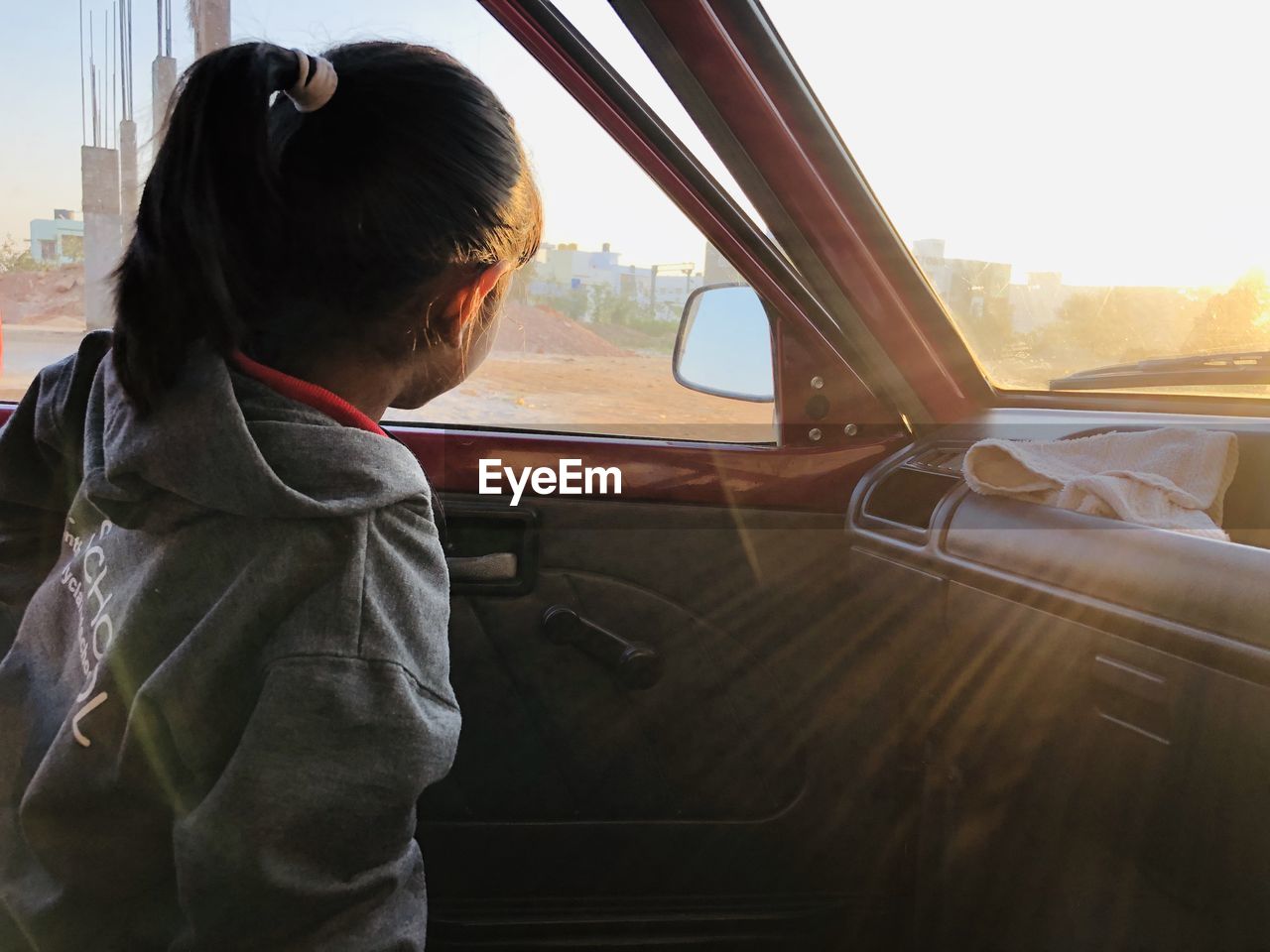 Side view of child looking through car window