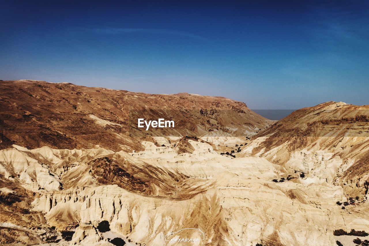 Scenic view of mountains against blue sky