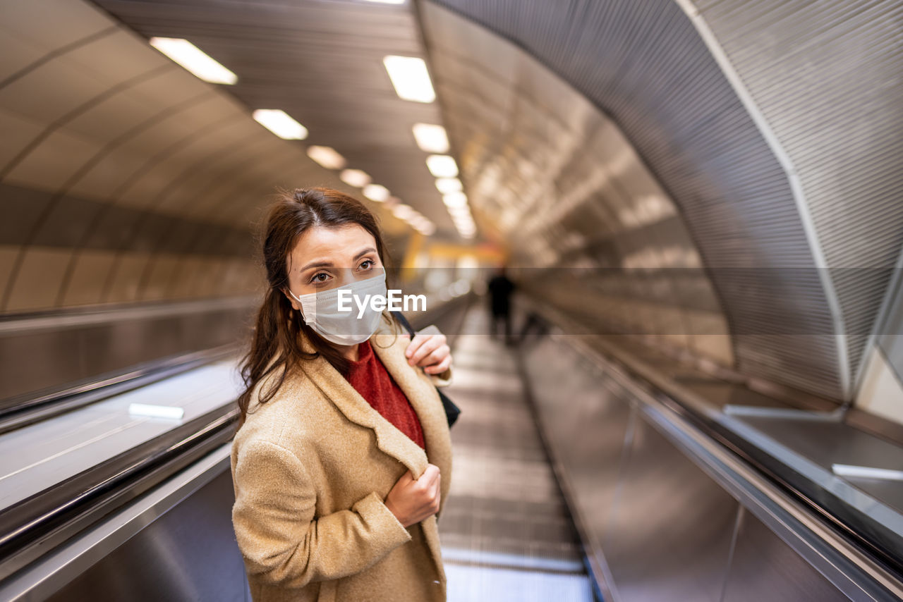 High angle view of woman wearing mask on escalator