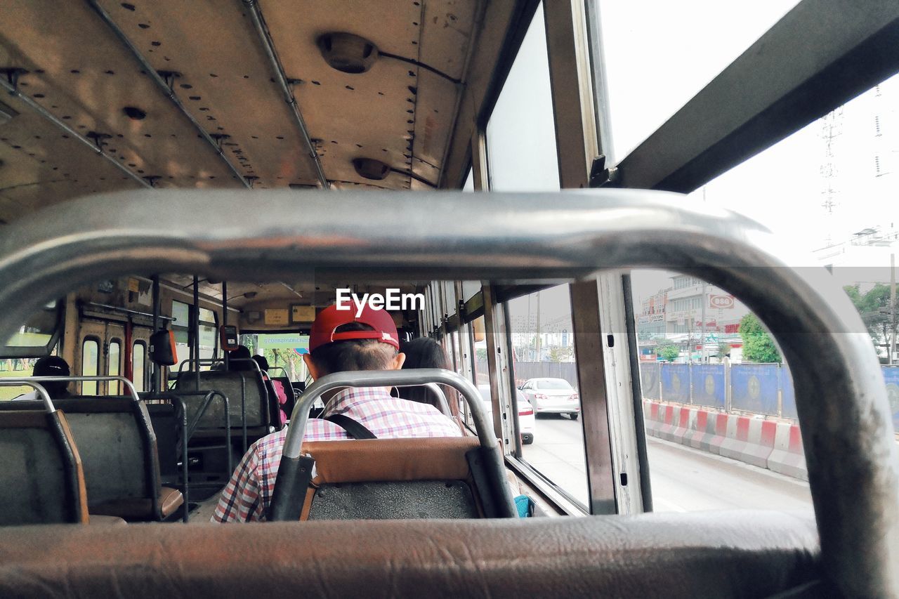 Rear view of man sitting in bus 
