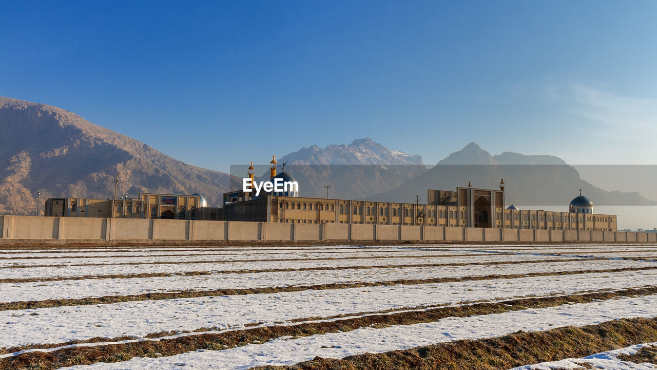 Built structure on snowcapped mountain against sky