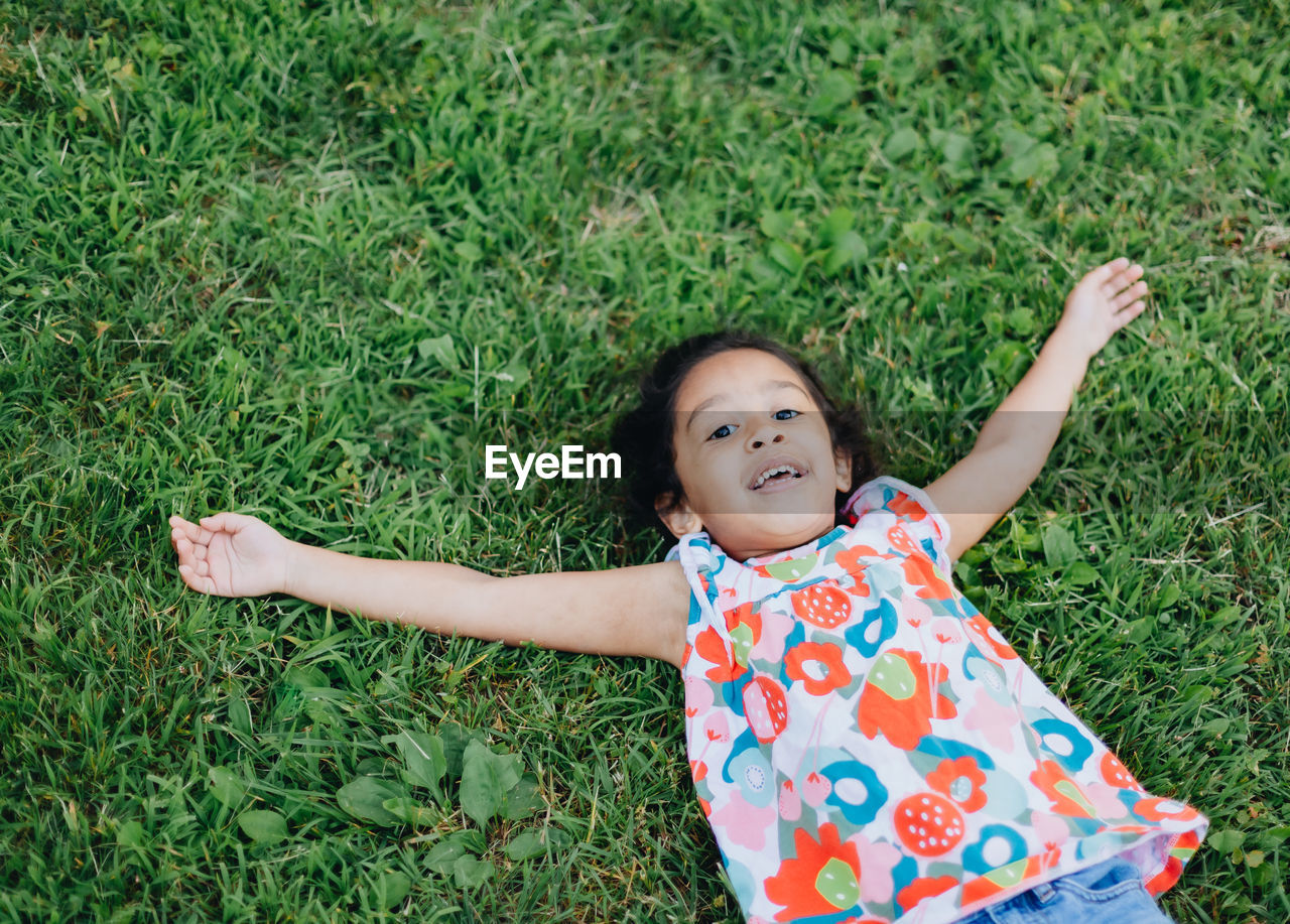 Diverse mixed race pre school girl outdoors during summer having fun at playground park 