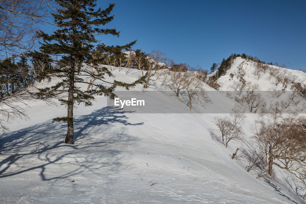 Scenic view of snow covered mountains against clear sky