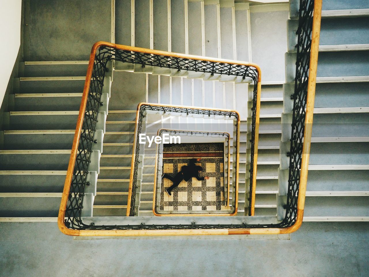 High angle view of man lying by spiral staircase