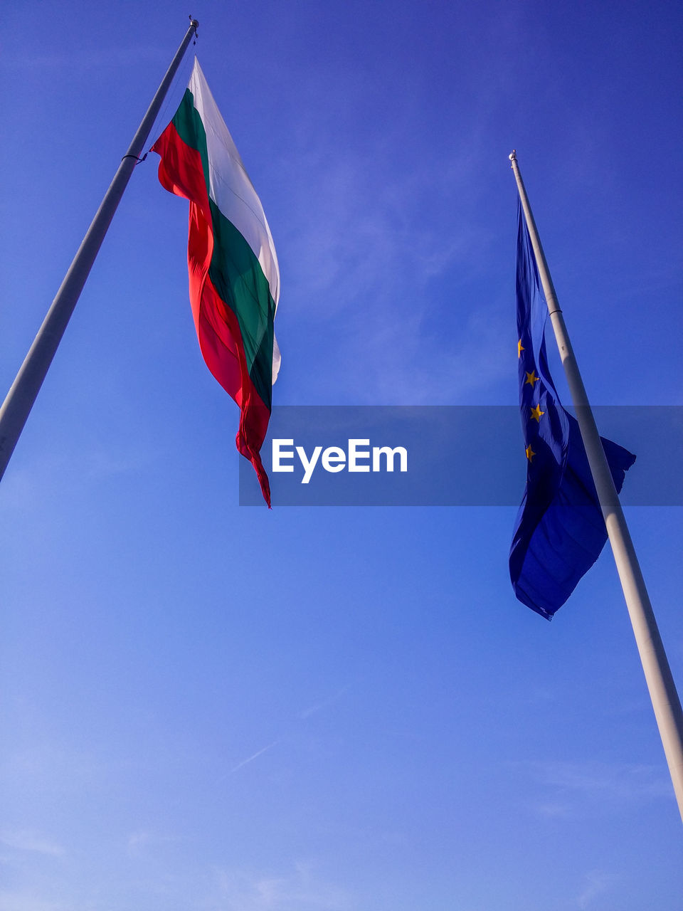 LOW ANGLE VIEW OF RED FLAG AGAINST BLUE SKY