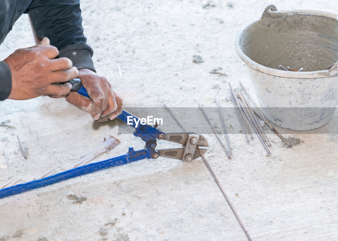 Big cutting pliers cut steel wire rod in construction site.