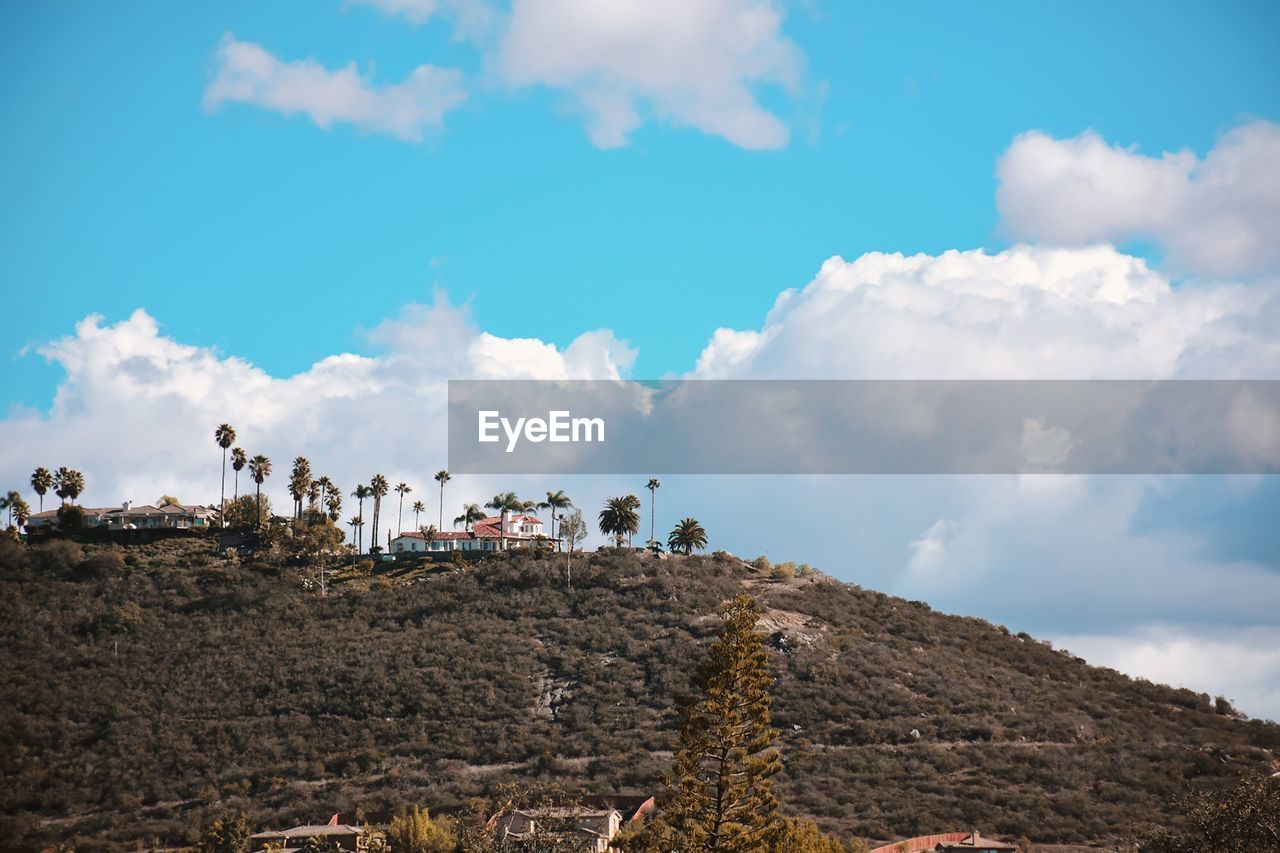 PANORAMIC VIEW OF BUILDINGS AGAINST CLOUDY SKY