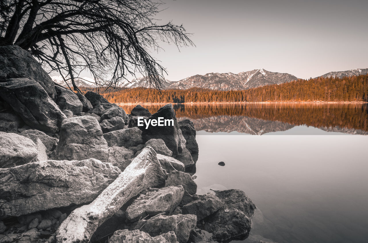 Reflection of rocks in lake against sky