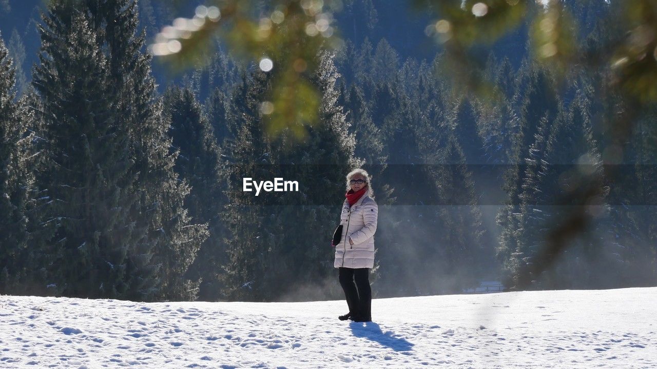 rear view of man standing on snow covered field