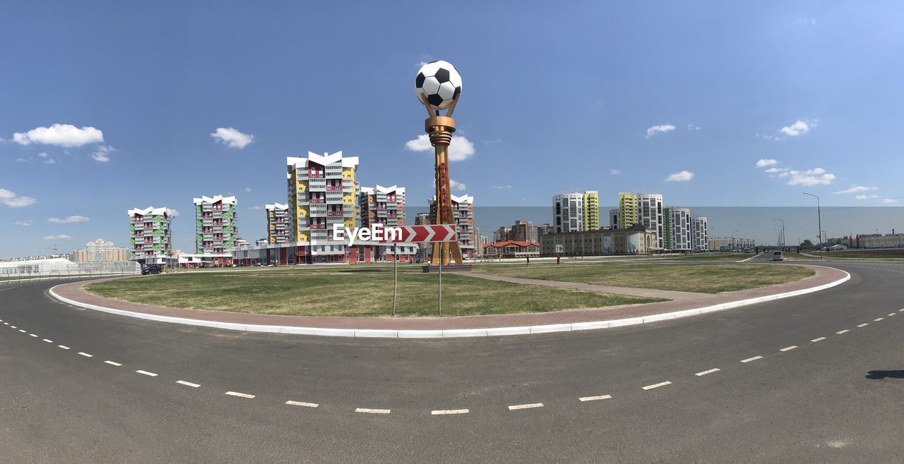 STREET BY BUILDINGS AGAINST SKY