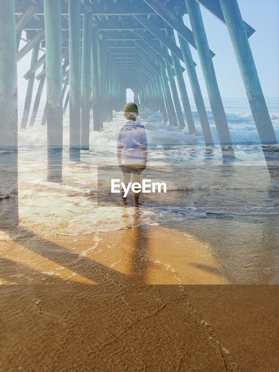 Double exposure image of boy standing on beach