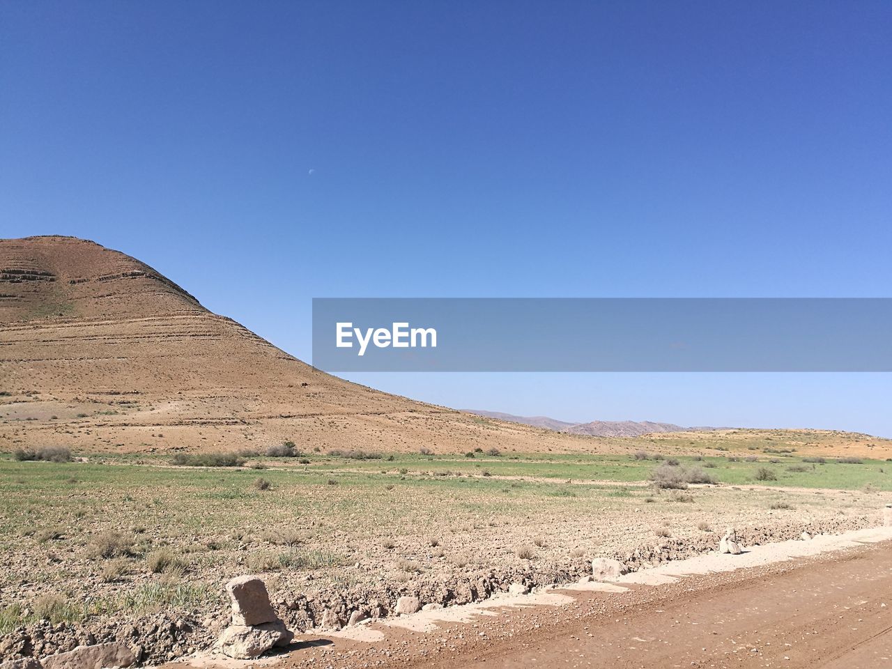 Scenic view of desert against clear blue sky