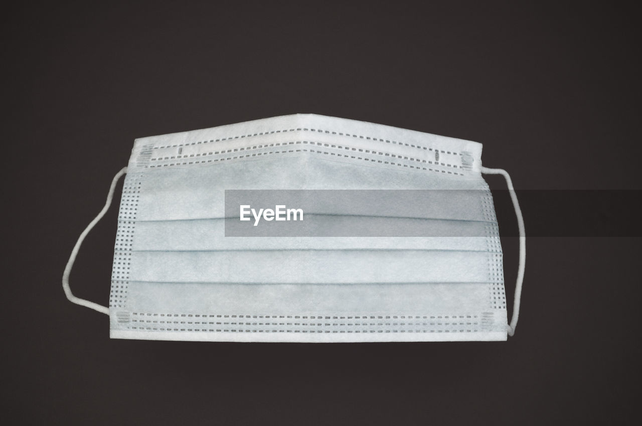 Close-up of surgical mask over black background