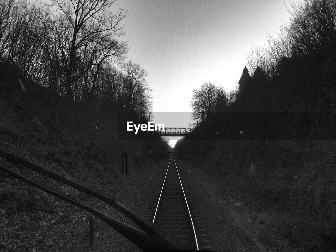 Railway tracks amidst mountains seen through train windshield