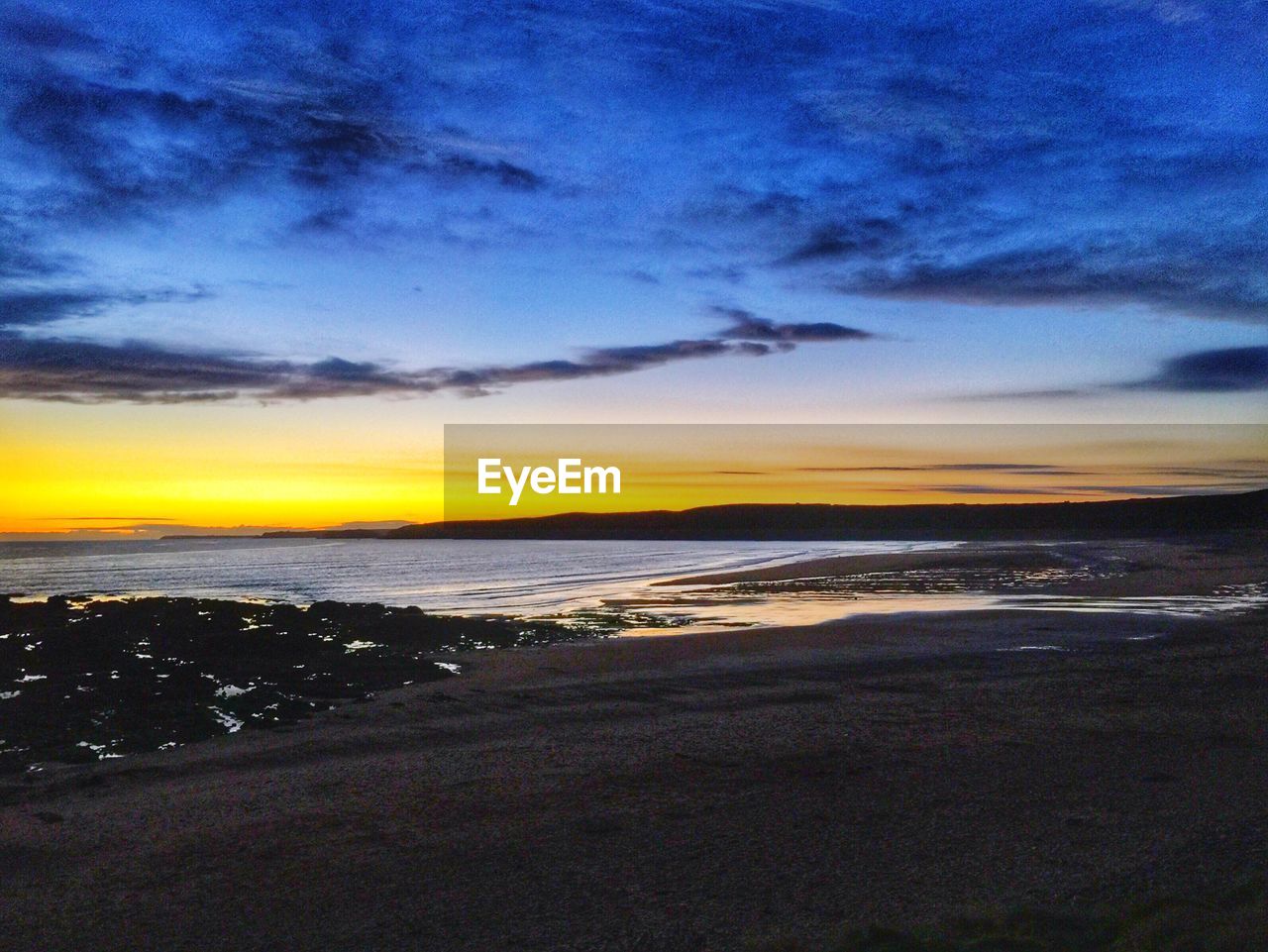 Scenic view of calm sea at sunset