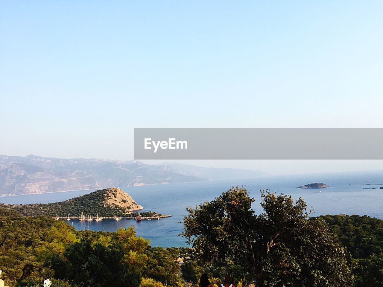 SCENIC VIEW OF SEA AND MOUNTAINS AGAINST CLEAR SKY