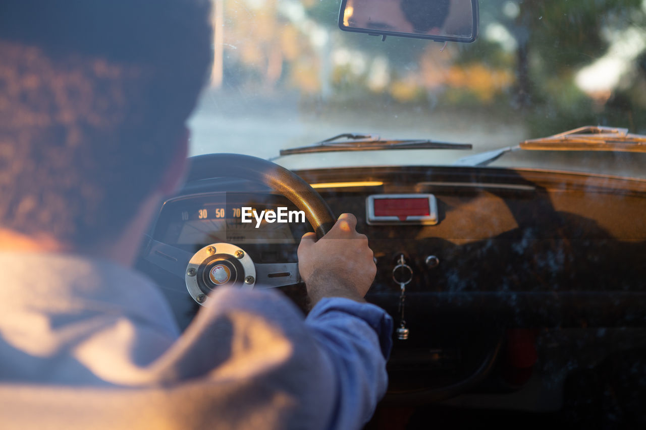 Rear view of man driving car