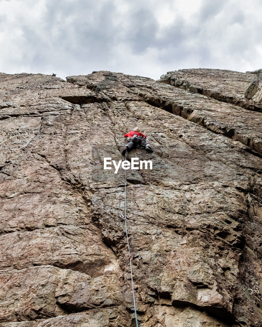 Low angle view of person on cliff against sky