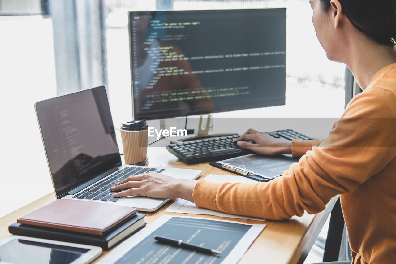 MIDSECTION OF MAN USING LAPTOP