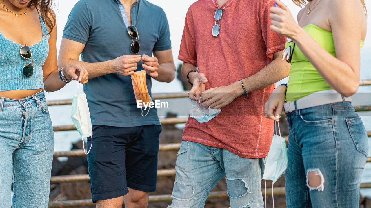 Young people holding safety mask new normal after covid-19  coronavirus pandemic lockdown.