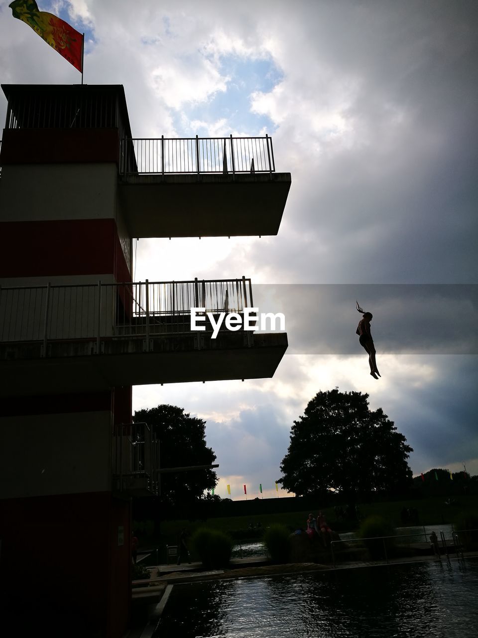 Low angle view of silhouette woman diving into swimming pool