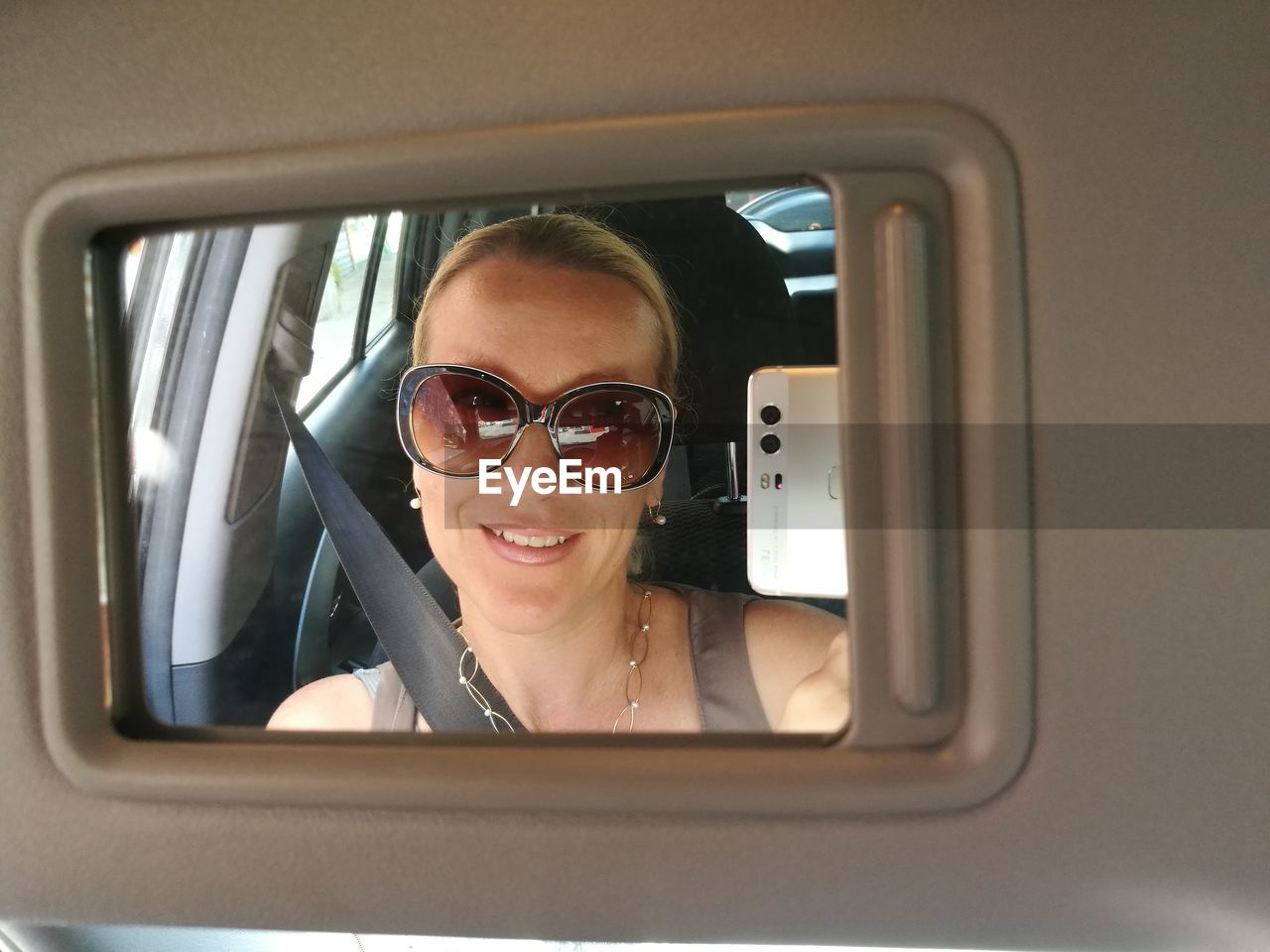 Reflection of woman on mirror in traveling in car