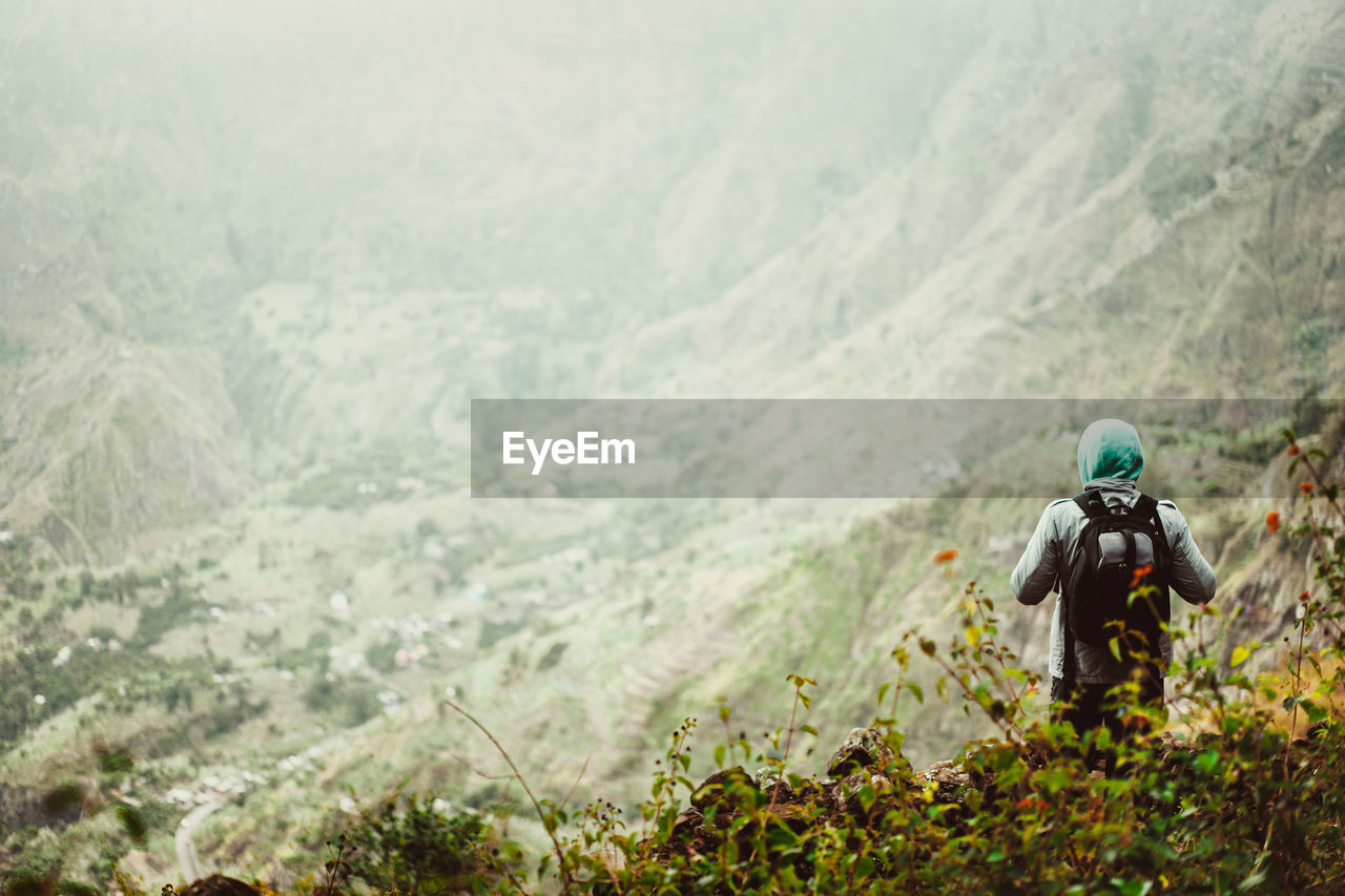 Man standing on land against mountains