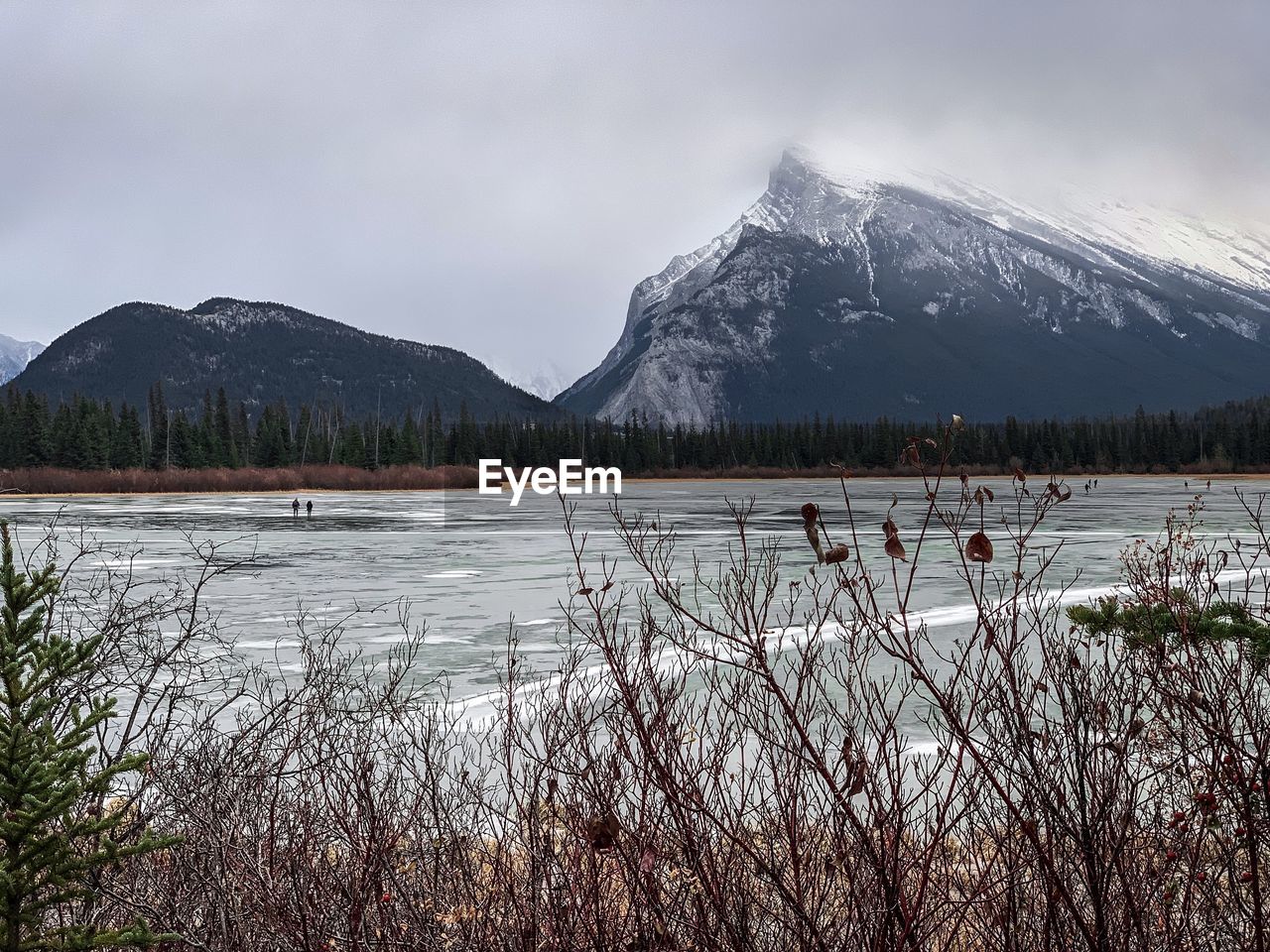 Scenic view of lake by snowcapped mountains against sky