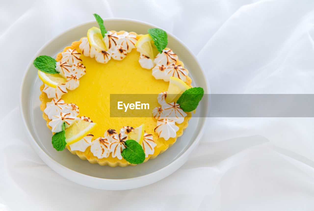 Lemon tart citrus cake in white dish and white cloth background, cake and bakery concept