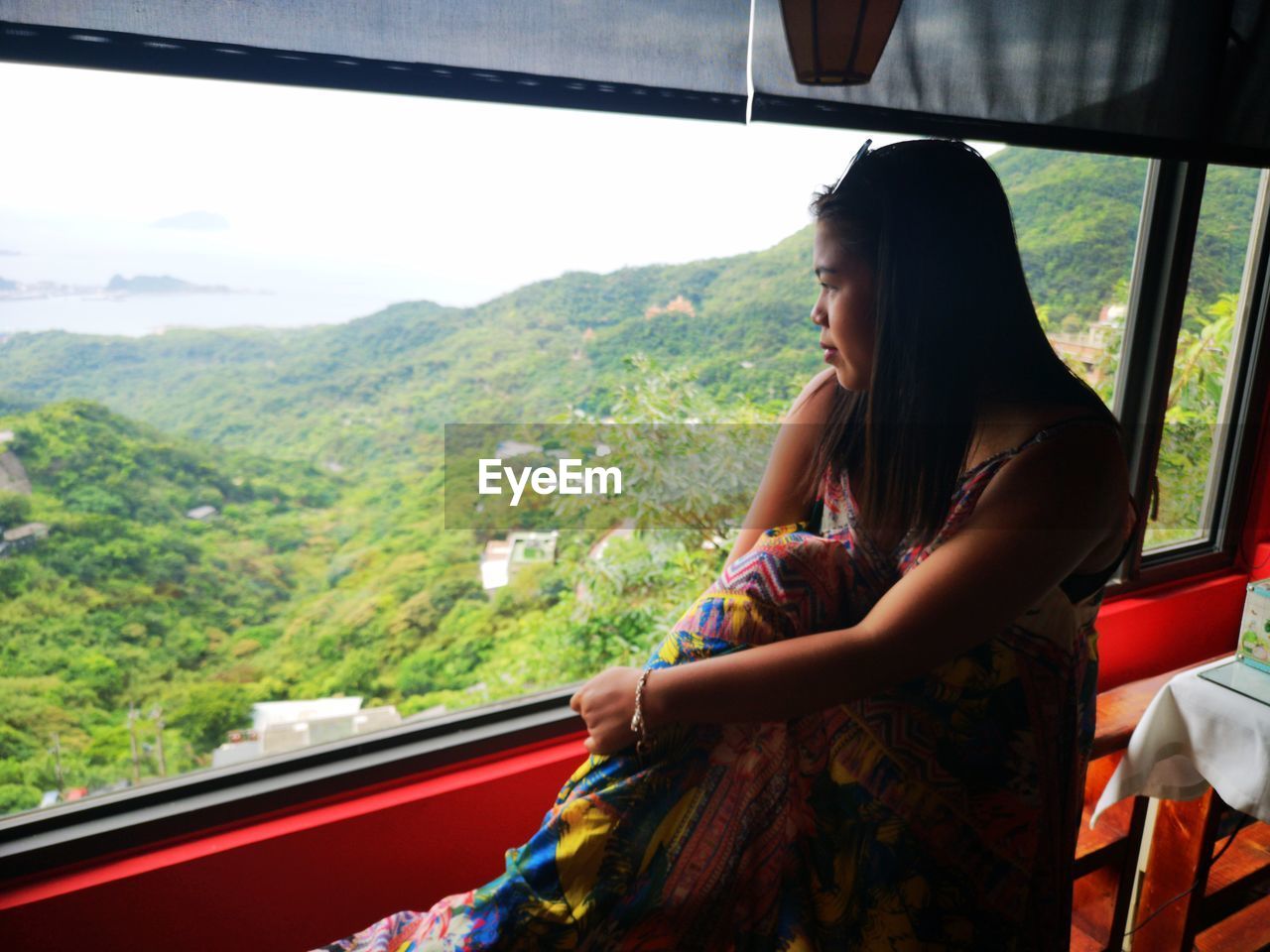 Woman looking at mountains through window