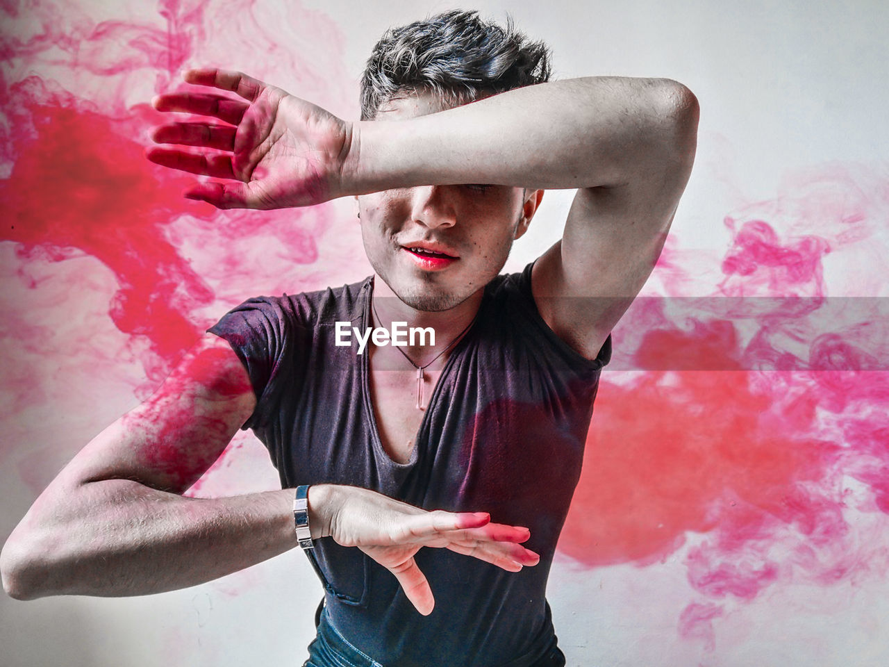 Young man standing amidst powder paint 