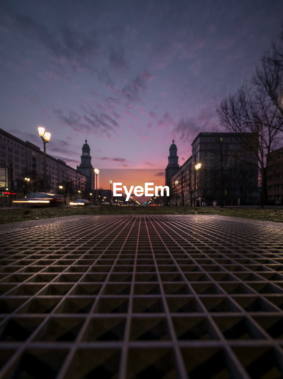 SURFACE LEVEL OF ILLUMINATED STREET LIGHTS AGAINST SKY AT SUNSET