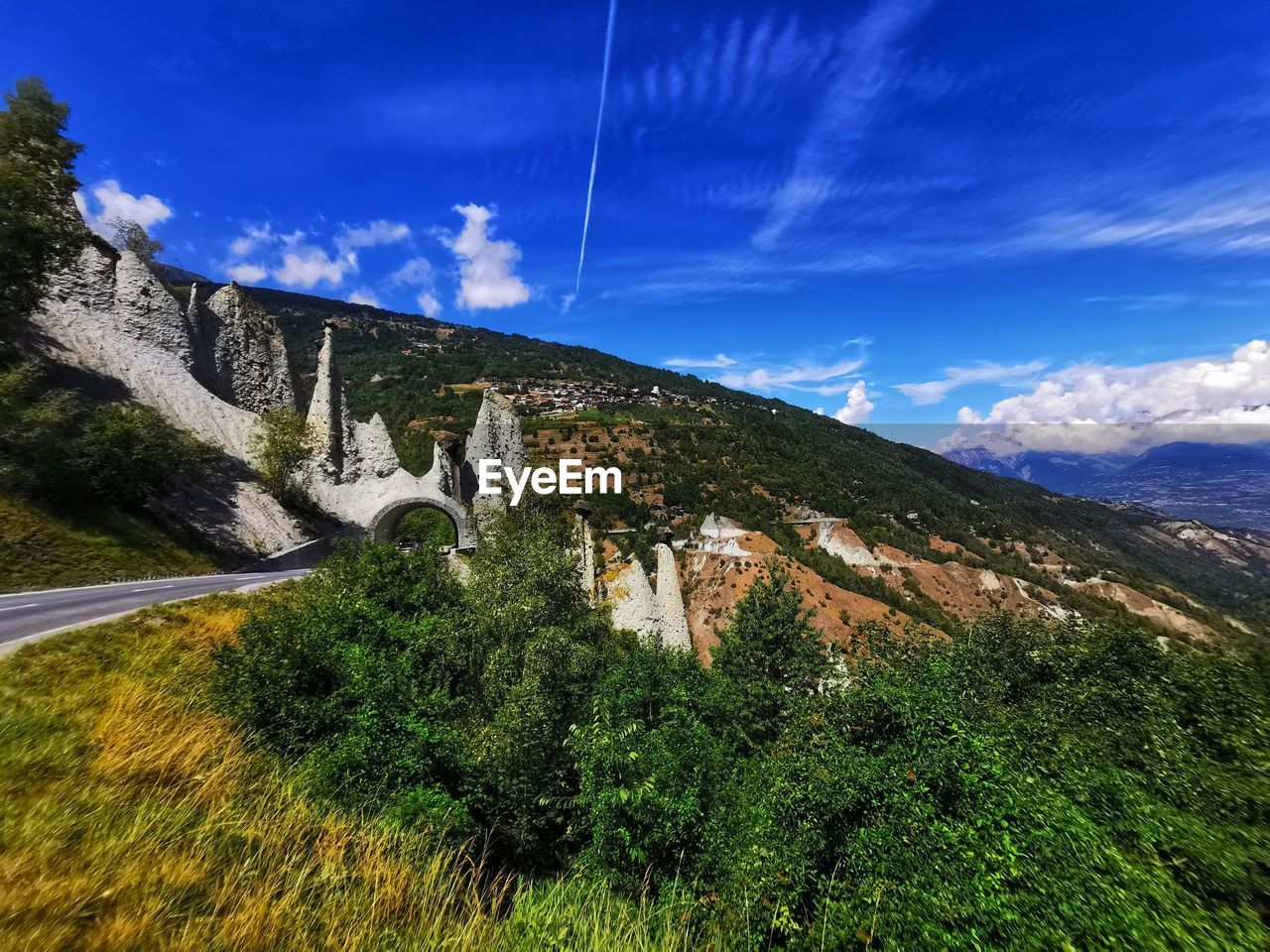 sky, mountain range, scenics - nature, mountain, nature, plant, environment, cloud, beauty in nature, landscape, land, tree, architecture, no people, travel destinations, travel, mountain pass, blue, non-urban scene, tranquility, tranquil scene, built structure, green, outdoors, valley, grass, plateau, water, road, tourism, day, ridge, idyllic, transportation, forest, meadow, wilderness, building