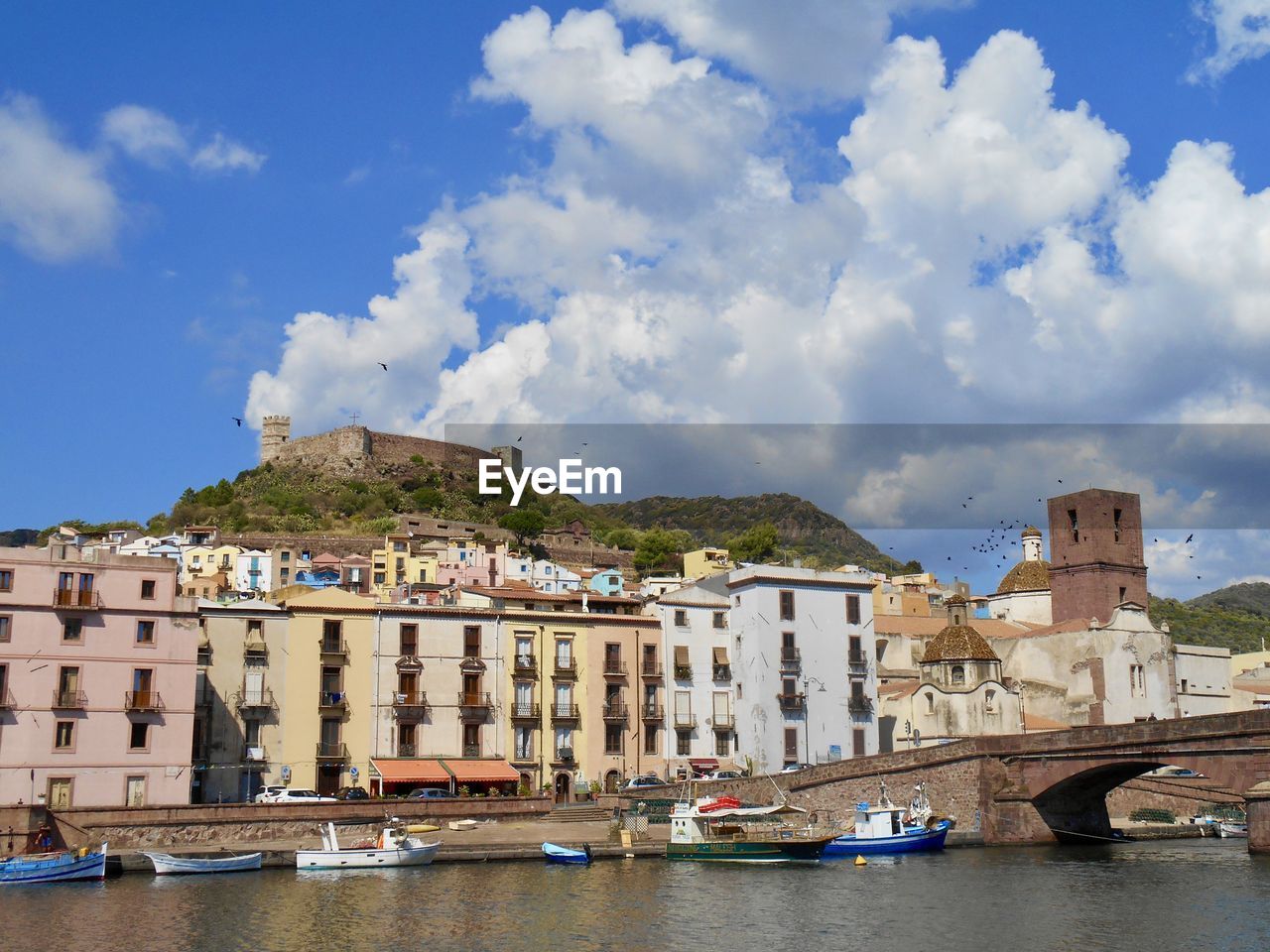 architecture, built structure, building exterior, water, sky, city, building, travel destinations, town, sea, nature, travel, transportation, cloud, nautical vessel, vacation, tourism, mode of transportation, residential district, body of water, waterfront, land, coast, house, blue, cityscape, vehicle, no people, harbor, trip, day, landscape, waterway, outdoors, holiday, bridge, history, ship, the past, beach, environment, old, city life, boat