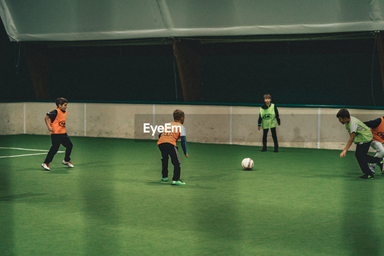 GROUP OF PEOPLE PLAYING SOCCER BALL ON FIELD