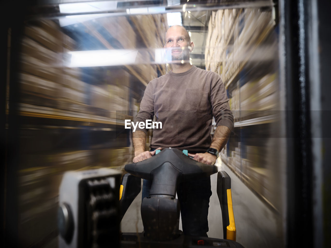 Warehouse worker pushing hand truck in alley