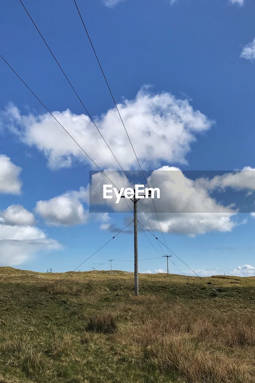 LOW ANGLE VIEW OF ELECTRICITY PYLON ON FIELD