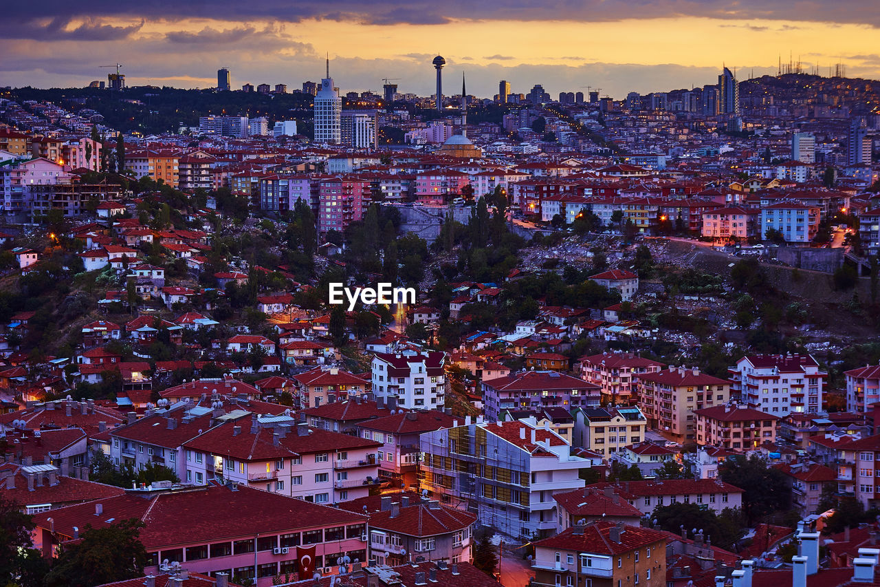 HIGH ANGLE VIEW OF ILLUMINATED CITY AGAINST SKY