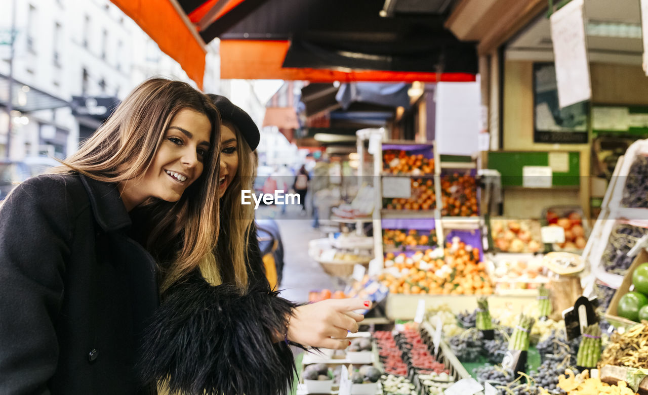 France, paris, two young women at a street market in montmartre