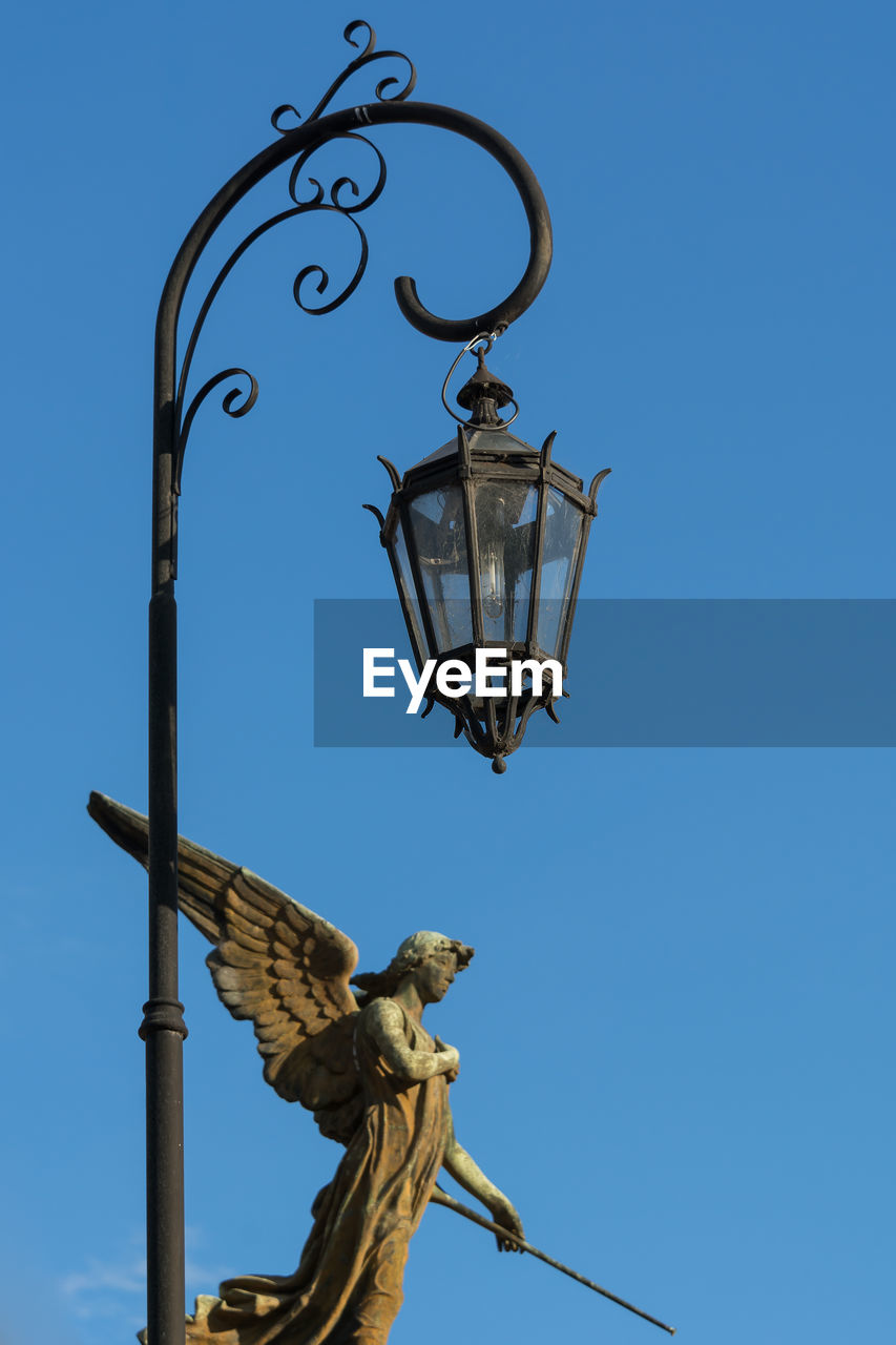 Low angle view of statue against clear blue sky