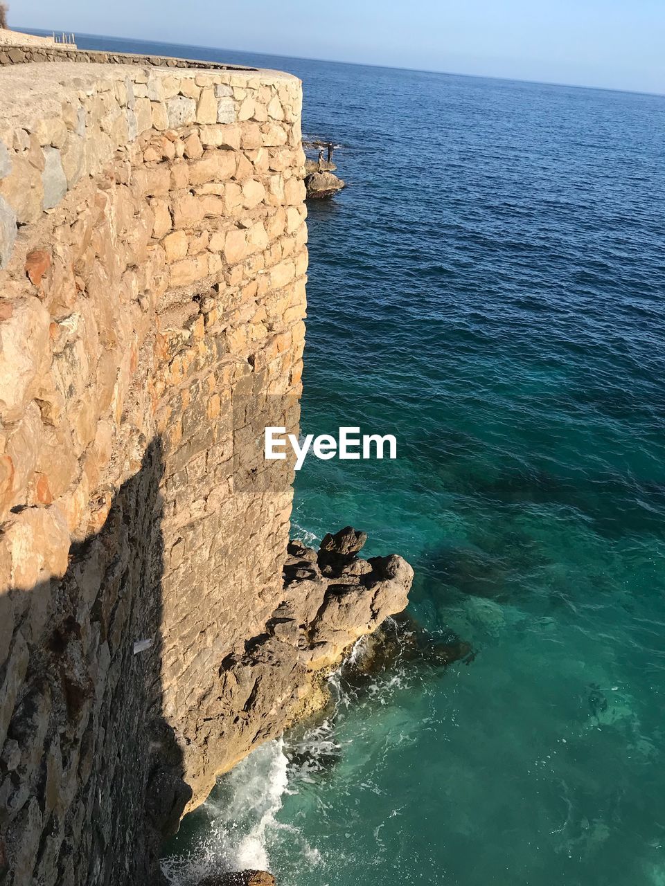 View of rock formation in sea against sky