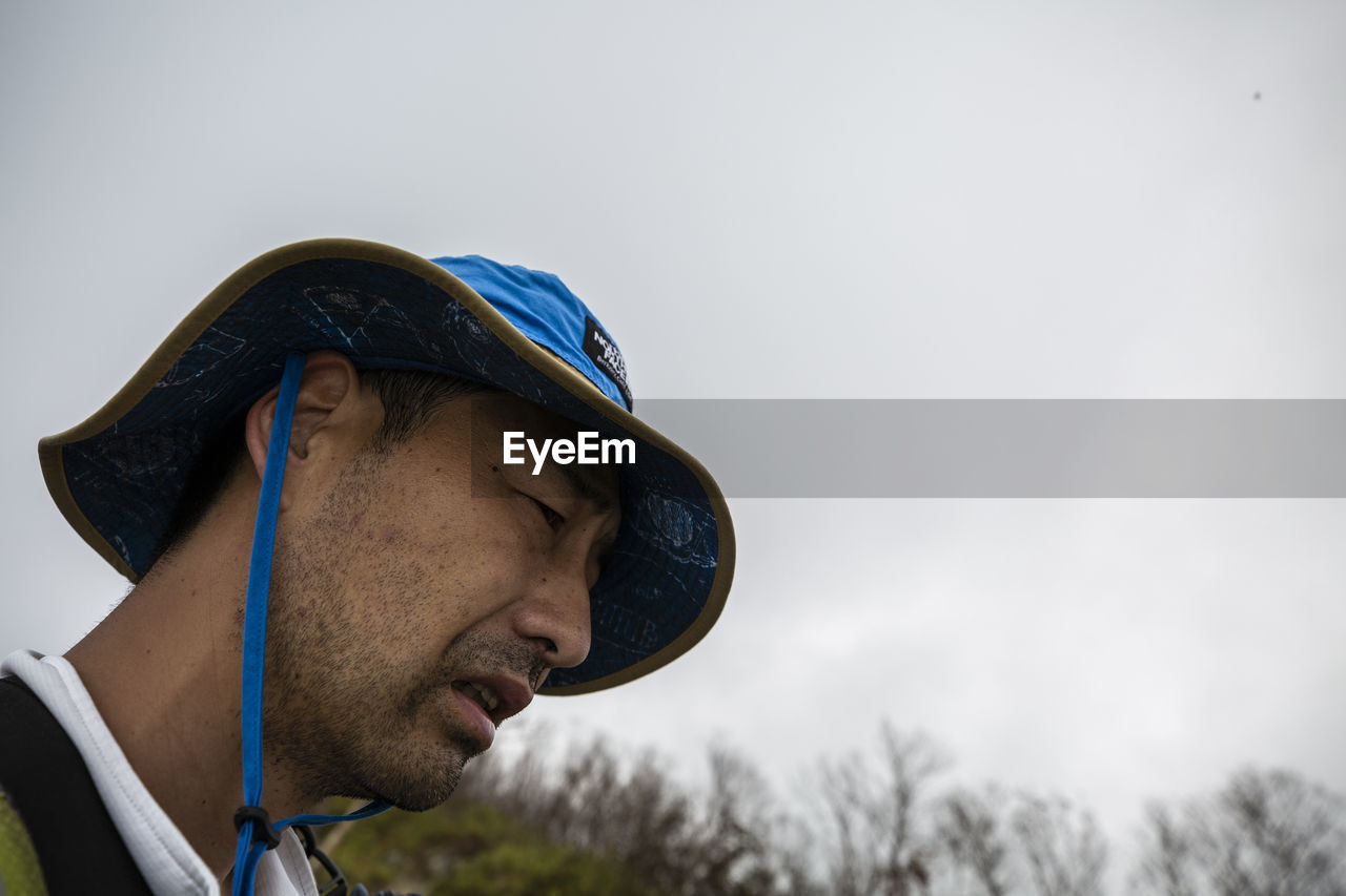 Low angle view of man with hat against clear sky