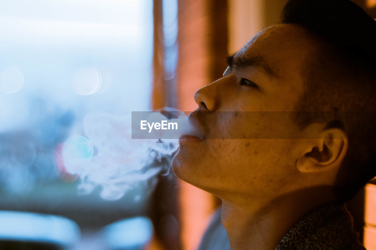 Close-up of man exhaling smoke