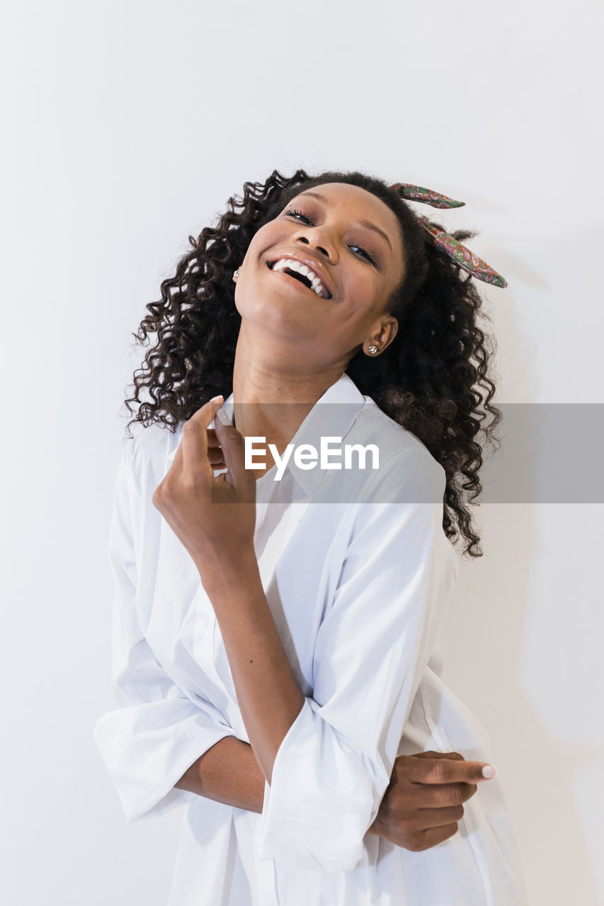 Happy young woman with head back against white background