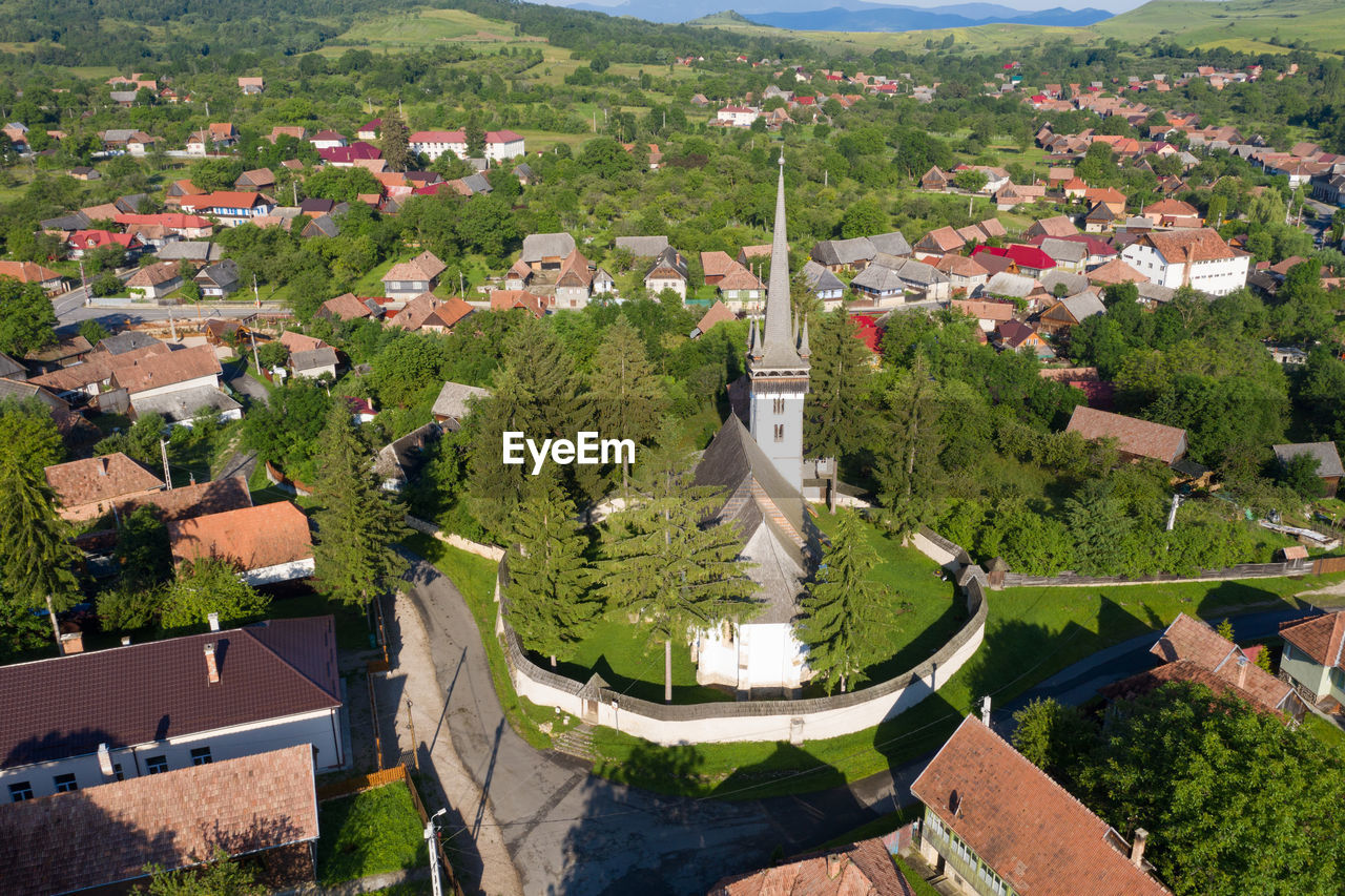 Aerial drone point of view of a whitewashed protestant church in manastireni, transylvania, romania