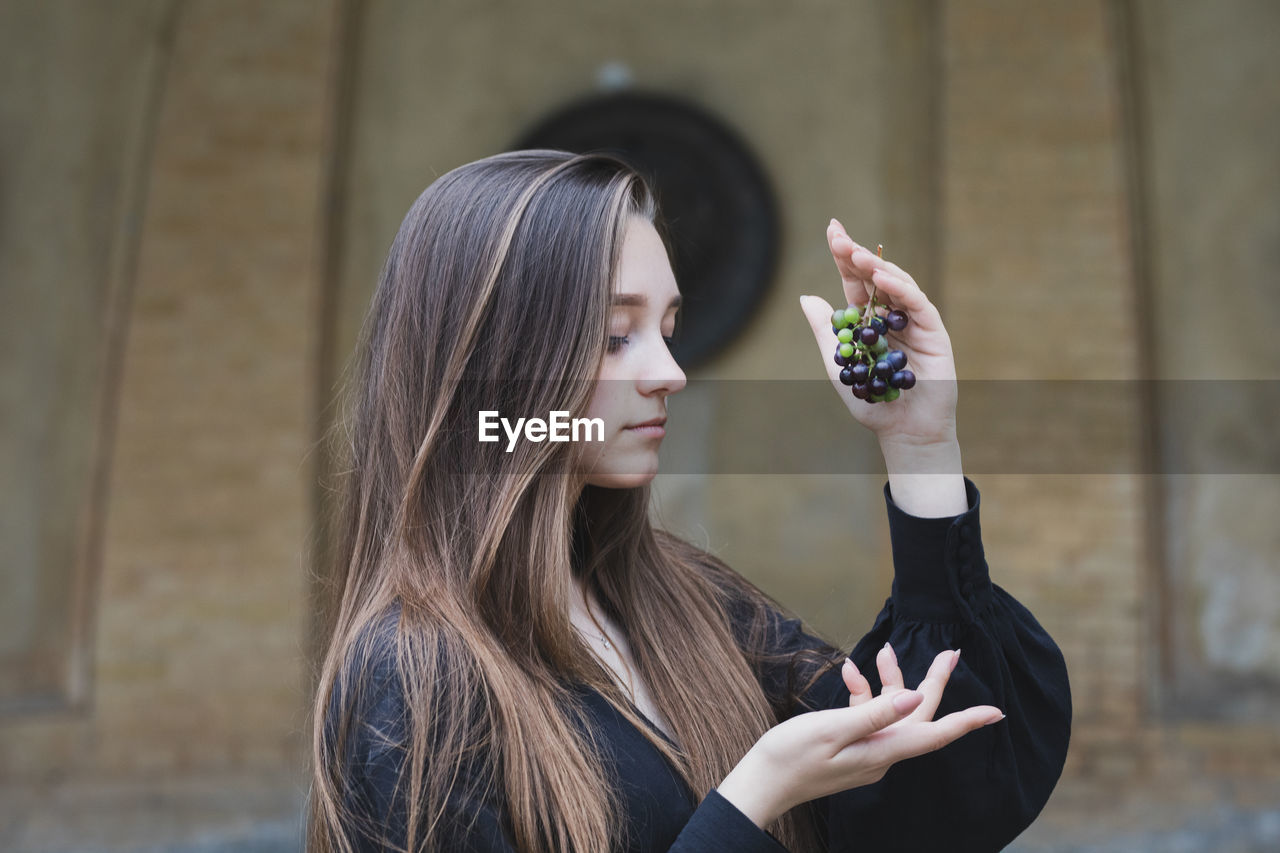 Portrait of young woman holding mobile phone